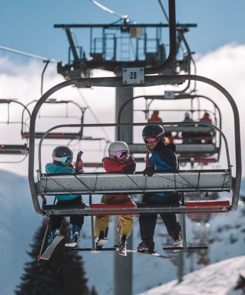 Family sat on a chairlift from behind