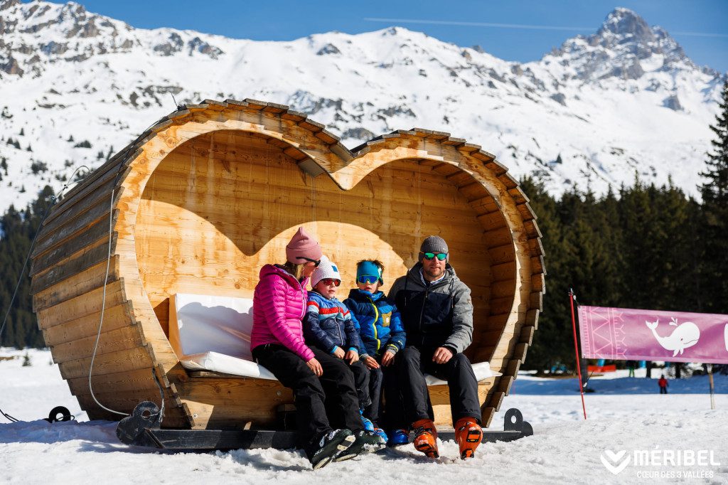 5 Fun Facts That Make Méribel One of the Best Alpine Destinations Meribel Family sat on heart shaped bech area in snow