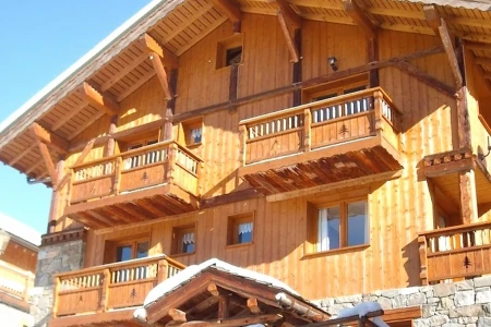 Exterior of Chalet Everest with timber balconies, stonework and snow-covered surroundings