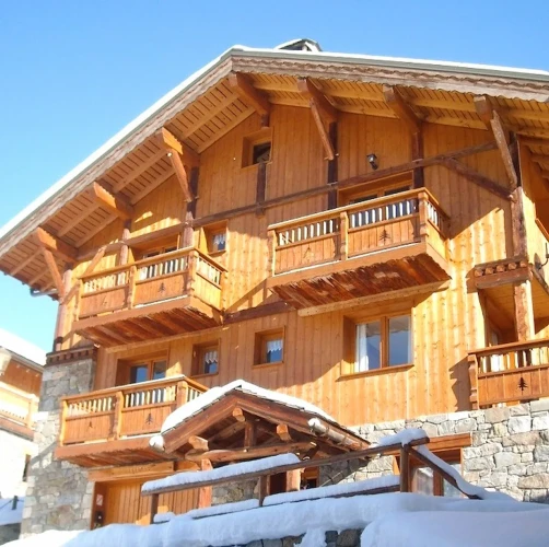 Exterior of Chalet Everest with timber balconies, stonework and snow-covered surroundings