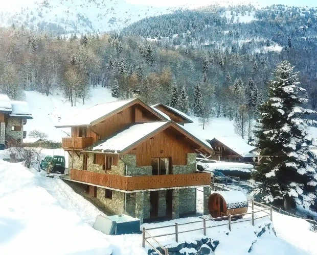 Full exterior view of Chalet Lagopede in the snow with a mountain forest backdrop