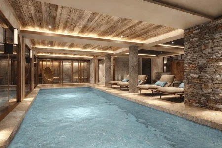 Shared indoor swimming pool for Apartment 101 with loungers, stone walls and spa-style interior